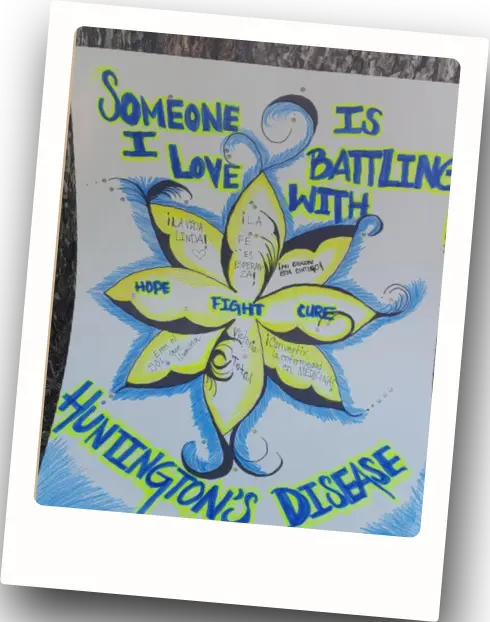 A handmade sign stating, “someone I love is battling with Huntington’s disease”.